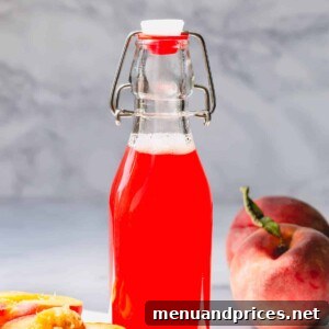 Homemade Peach Syrup in a tall glass bottle, ready to be enjoyed.