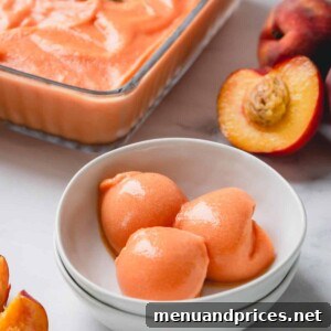 3 scoops of peach ice cream in a white bowl.