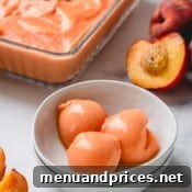 3 scoops of peach ice cream in a white bowl.