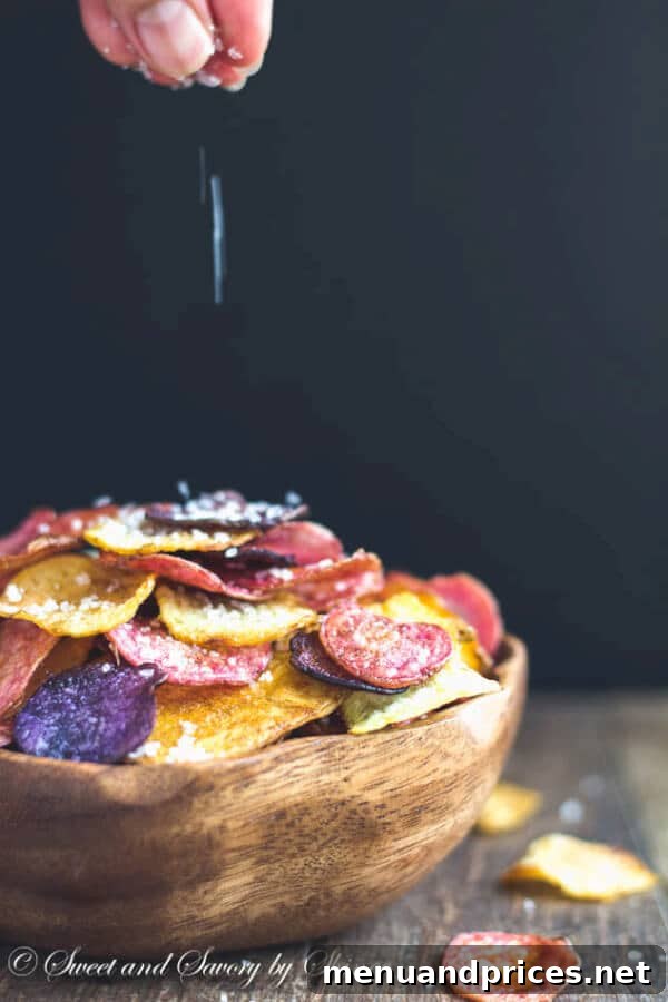 Ultra-Crisp Oven Potato Chips 6 Close-up of crispy baked potato chips seasoned with garlic and herbs, glistening with olive oil.
