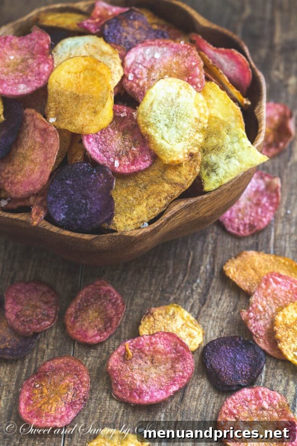 Ultra-Crisp Oven Potato Chips 7 A bowl of extra crispy baked potato chips paired with a glass of cold beer, set against a rustic background, highlighting their snack appeal.