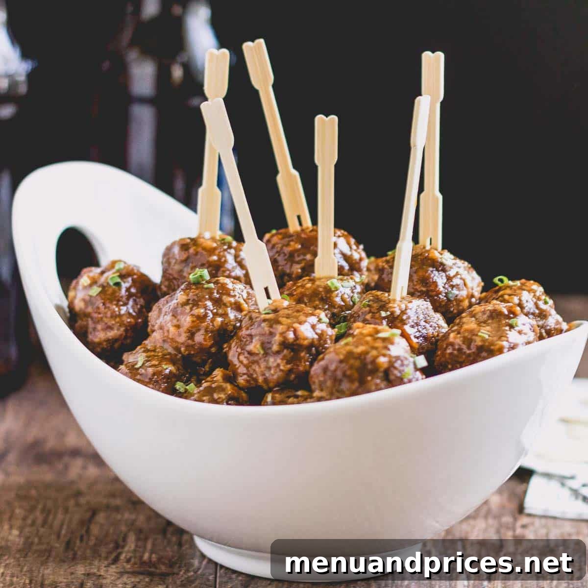 A bowl of Beer BBQ Meatballs, garnished with fresh parsley and toothpicks for easy serving.