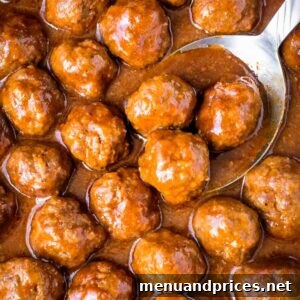 Beer bbq meatballs with a spoon dipping into the sauce.