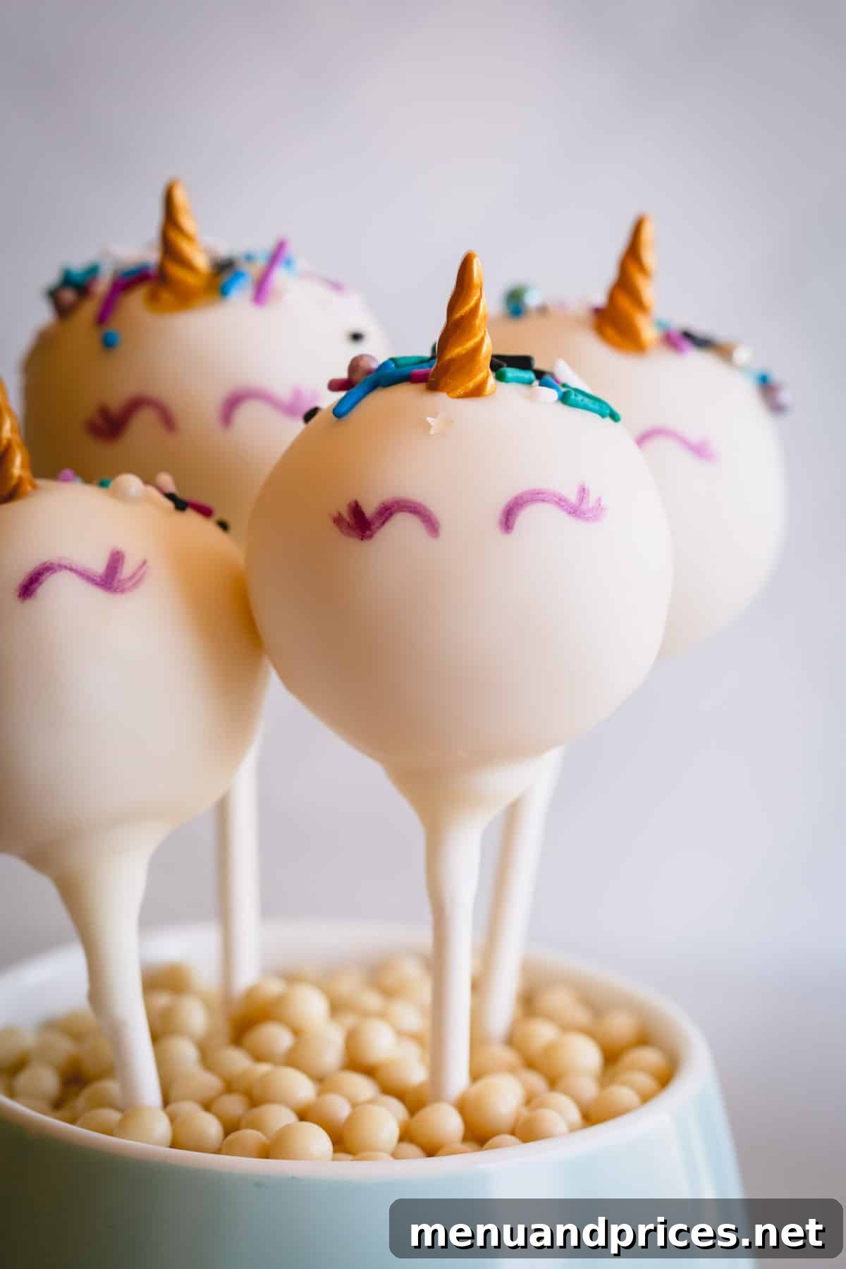 Foolproof Cake Pop Delight 9 Whimsical unicorn cake pops adorned with delicate details, arranged in a charming cup.