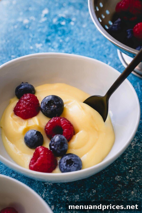 Mastering Classic French Pastry Cream 3 A small bowl of pastry cream topped with fresh blueberries and raspberries.