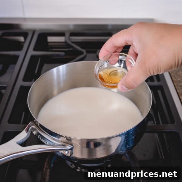 Mastering Classic French Pastry Cream 5 A saucepan with milk and vanilla extract on a burner, heating up.