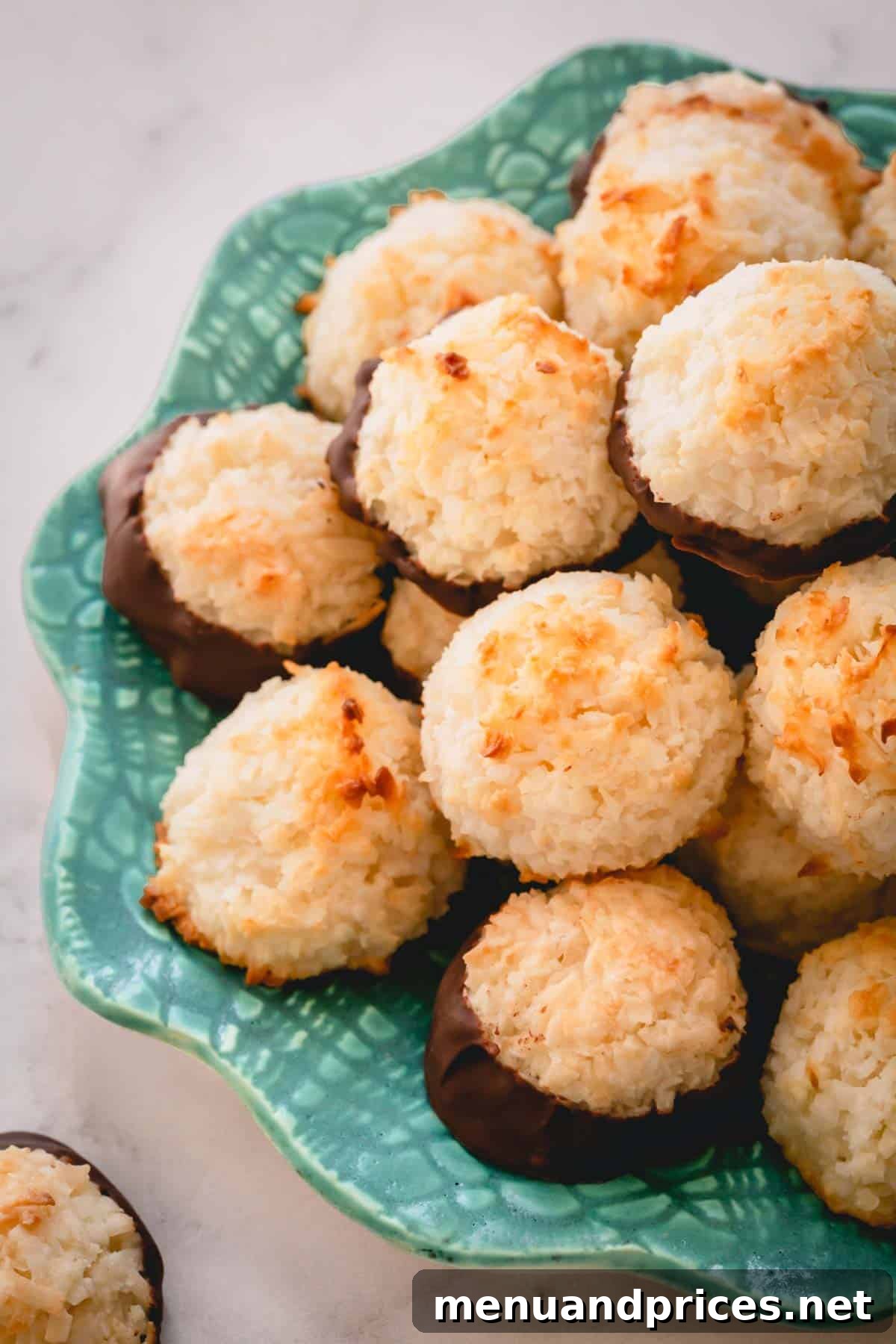 Ultimate Coconut Macaroons 2 A plate brimming with chocolate-dipped coconut macaroons, showcasing their inviting texture and rich chocolate coating.