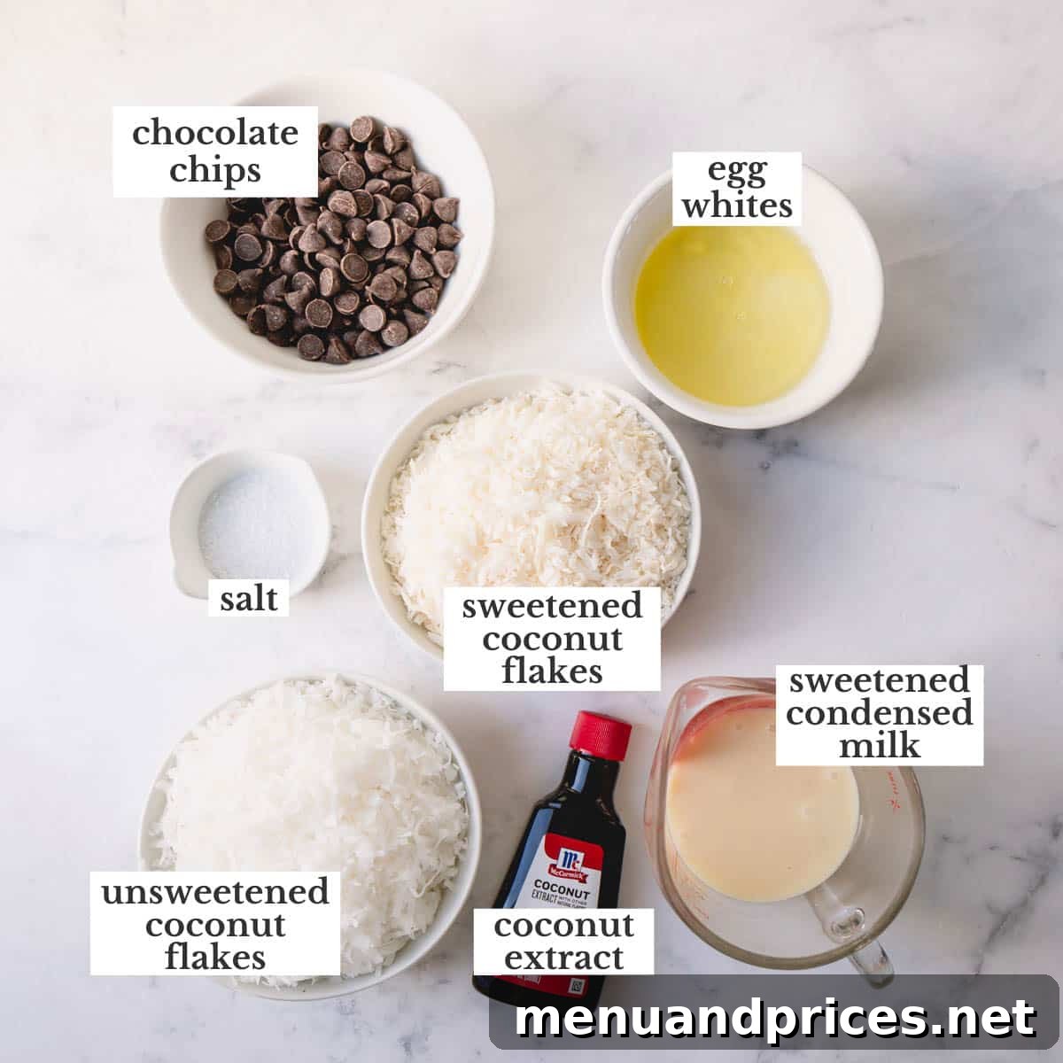 Ultimate Coconut Macaroons 4 A vibrant display of fresh ingredients for chocolate-dipped coconut macaroons, including bags of coconut, condensed milk, eggs, and chocolate chips.