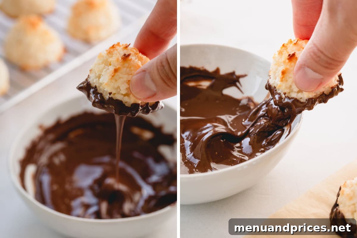Ultimate Coconut Macaroons 8 A close-up shot of a hand carefully dipping a baked coconut macaroon into a bowl of melted chocolate.