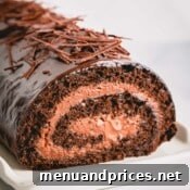 A chocolate roll cake with mousse filling, appealingly presented on a plate.