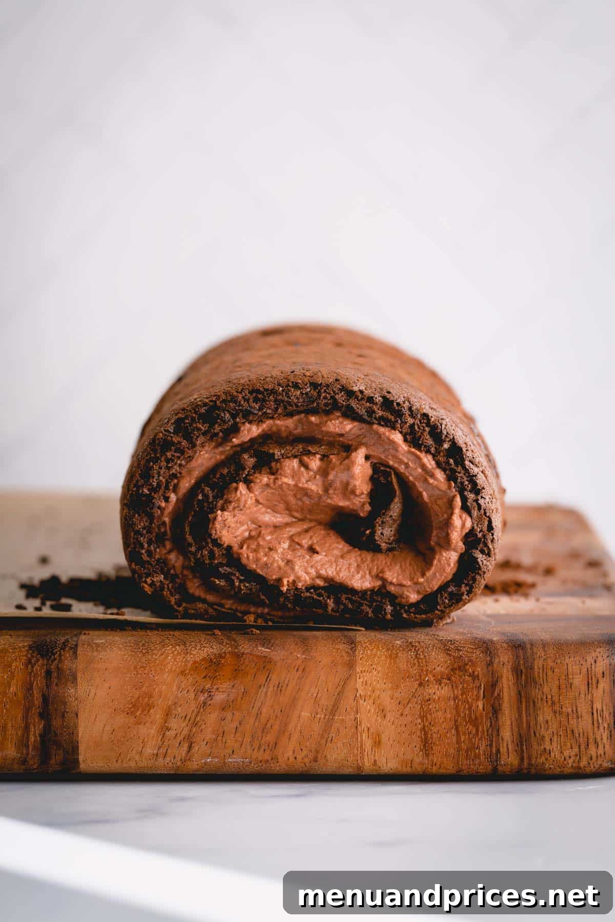 Sinful Chocolate Roll Cake 9 A beautifully completed chocolate roll cake, filled with rich chocolate mousse, perfectly chilled and ready for its final elegant ganache topping.