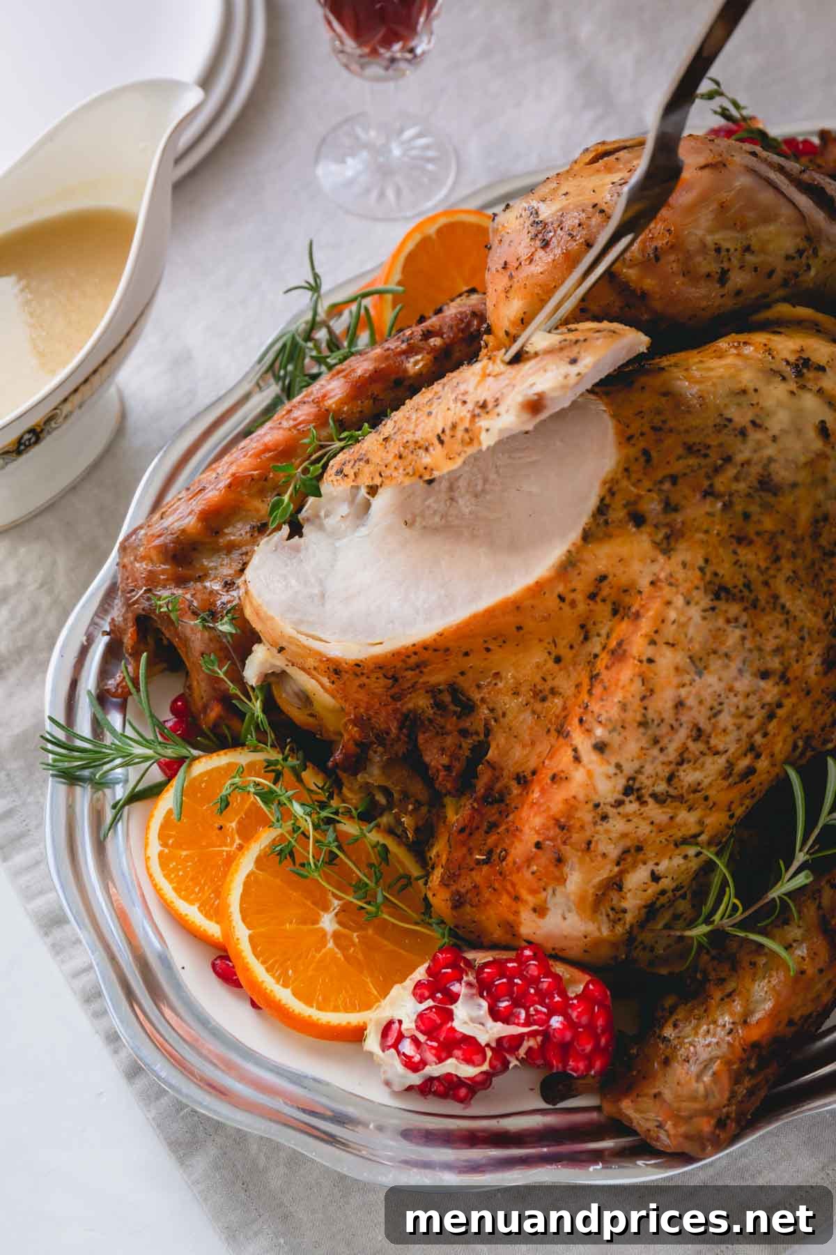Whole roasted turkey on a platter with a sliced breast, showing moist meat.