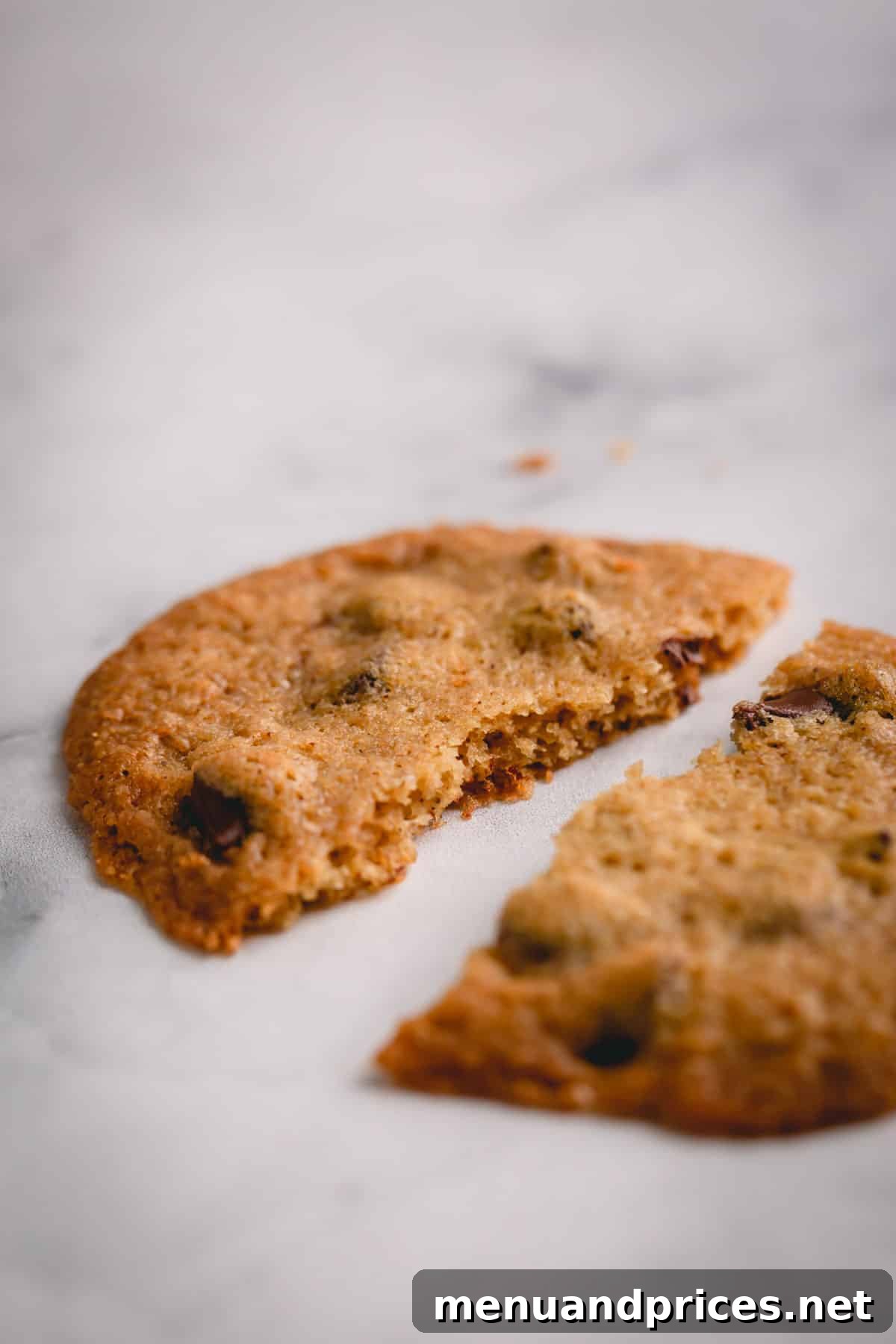 Golden Crunch Chocolate Chip Delights 11 A close-up shot of a crispy chocolate chip cookie broken in half, revealing its delicate, airy interior and melted chocolate pockets.