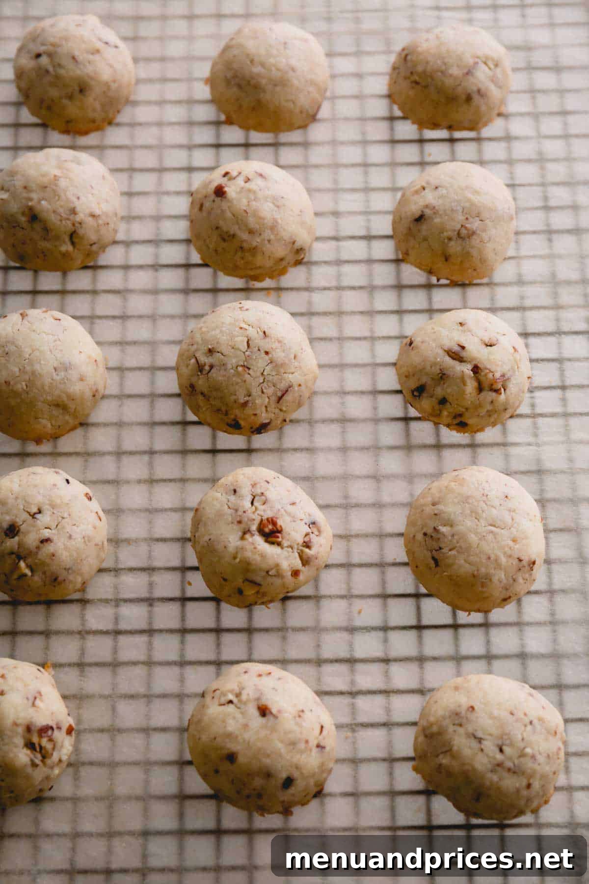 Buttery Pecan Snowball Cookies 11 Freshly baked snowball cookies resting on a wire rack.