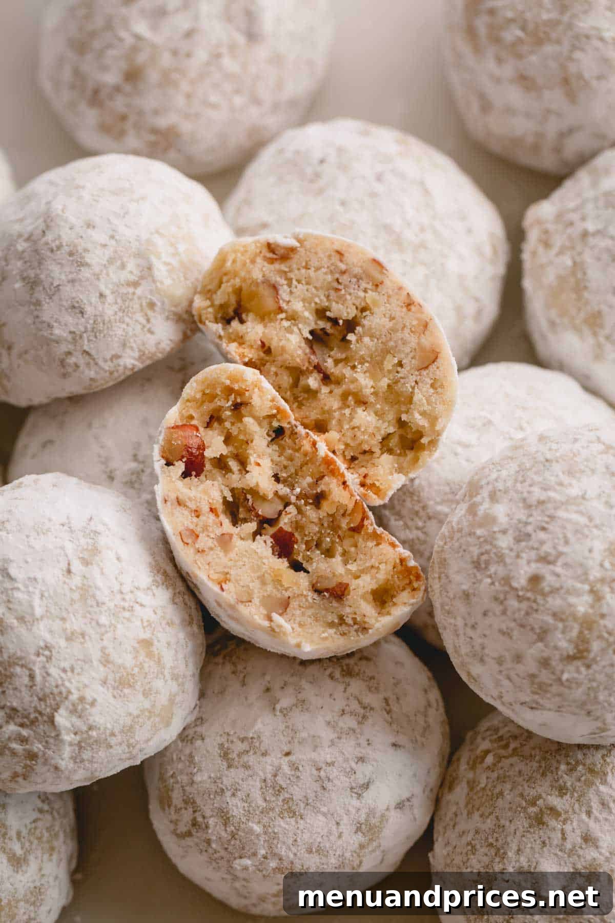 Buttery Pecan Snowball Cookies 3 A single Russian tea cake cookie, perfectly broken in half to reveal its crumbly, nutty interior.