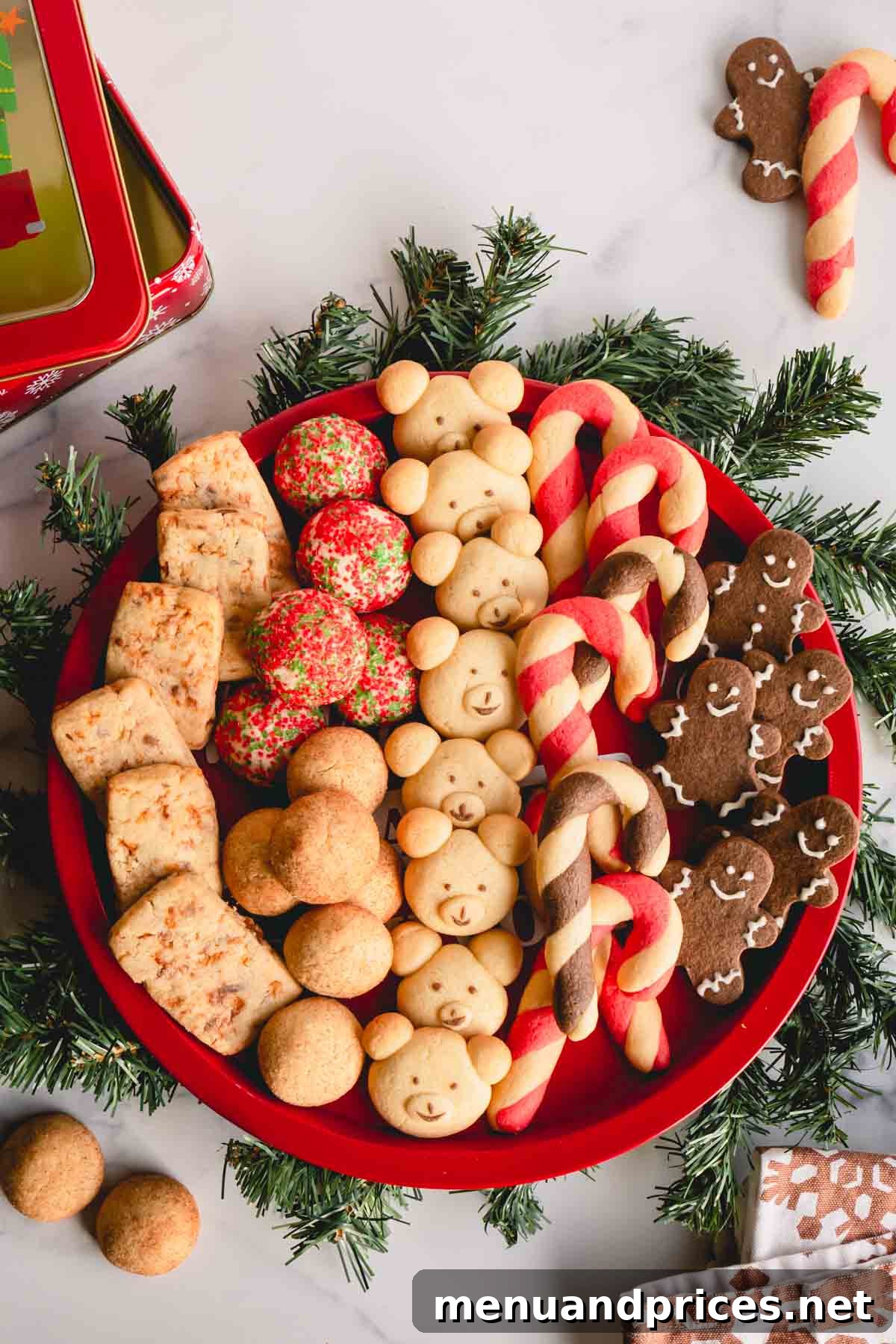 A round platter full of 6 varieties of of Christmas cookies, including chocolate, candy cane, snickerdoodle, teddy bear, butterfinger, and sprinkle cookies.