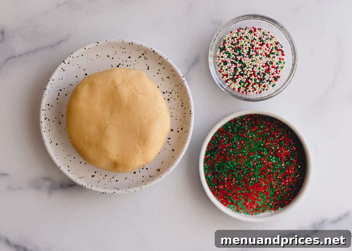 Cookie dough ball and 2 bowls of sprinkles and colored sugar, ready for holiday sprinkle cookies.