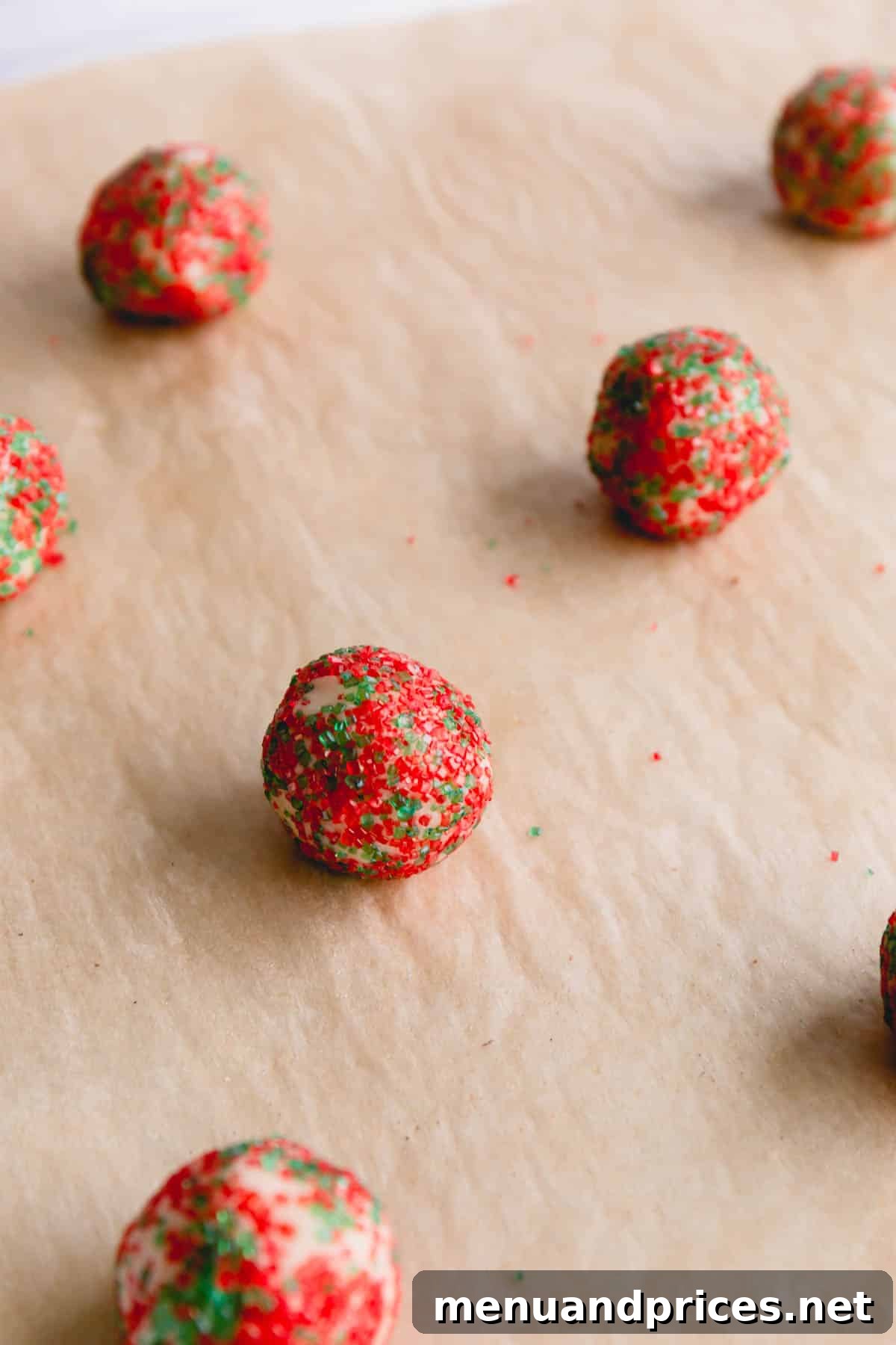 Small cookie dough balls rolled in a red and green sugars, ready for baking.
