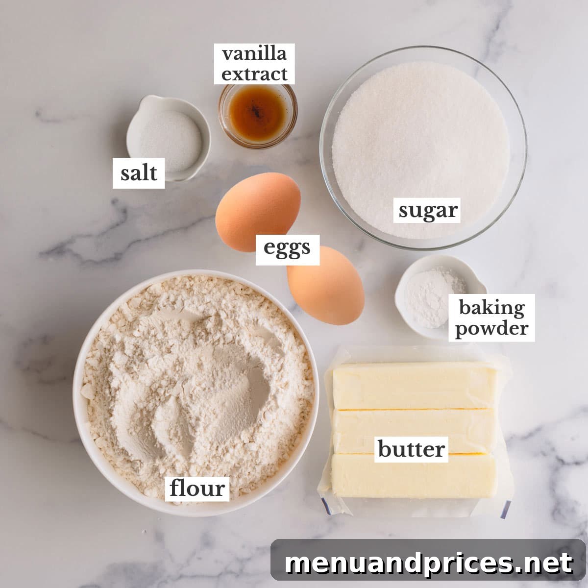 Butter cookie dough ingredients laid out: sticks of butter, eggs, sugar, flour, vanilla, baking powder, and salt.