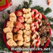 A round platter full of 6 varieties of of Christmas cookies.