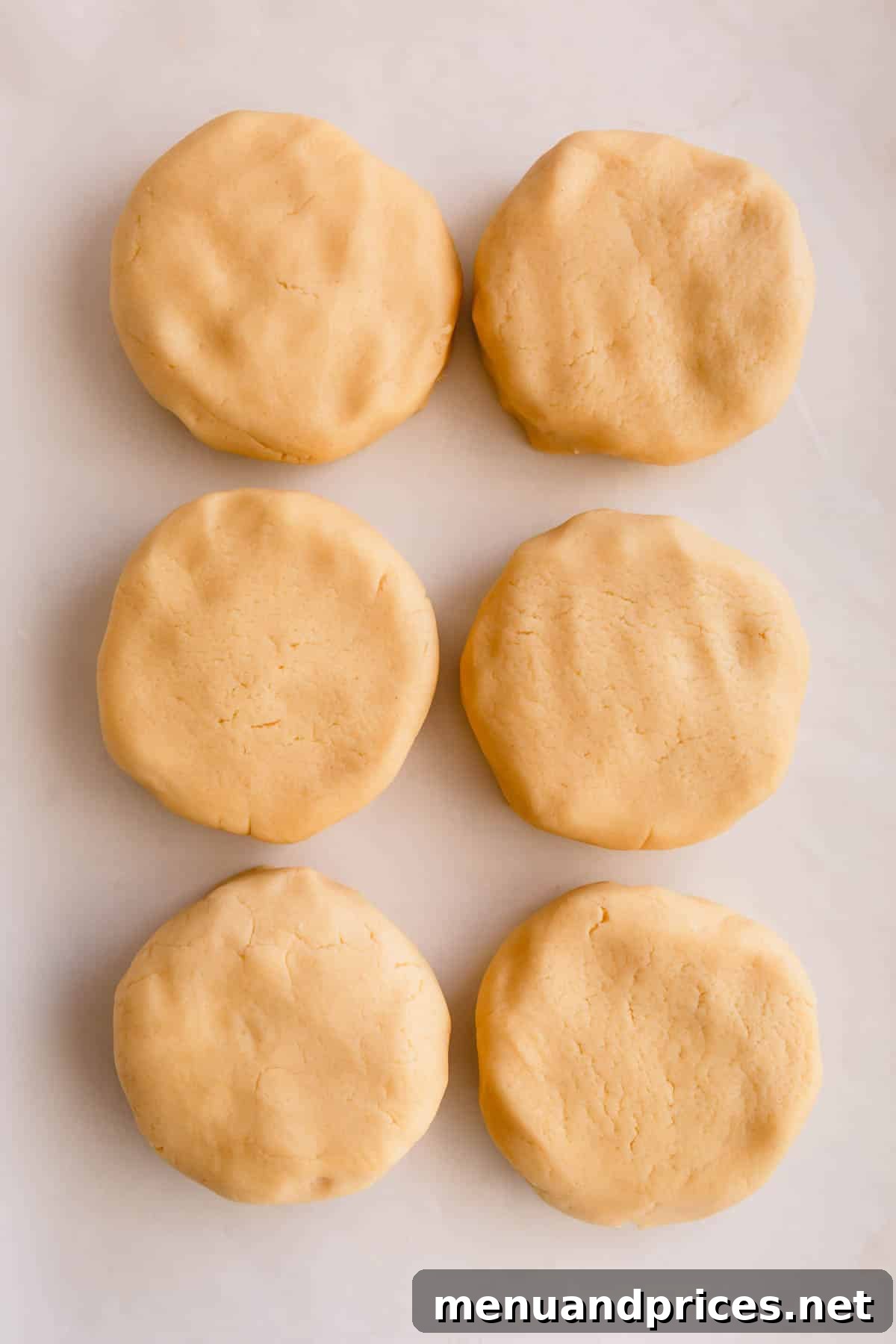 6 disks of butter cookie dough ready for different variations.