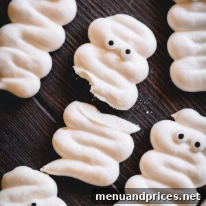 A few mummy meringue cookies with one is broken in half.