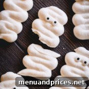 A few mummy meringue cookies with one is broken in half.