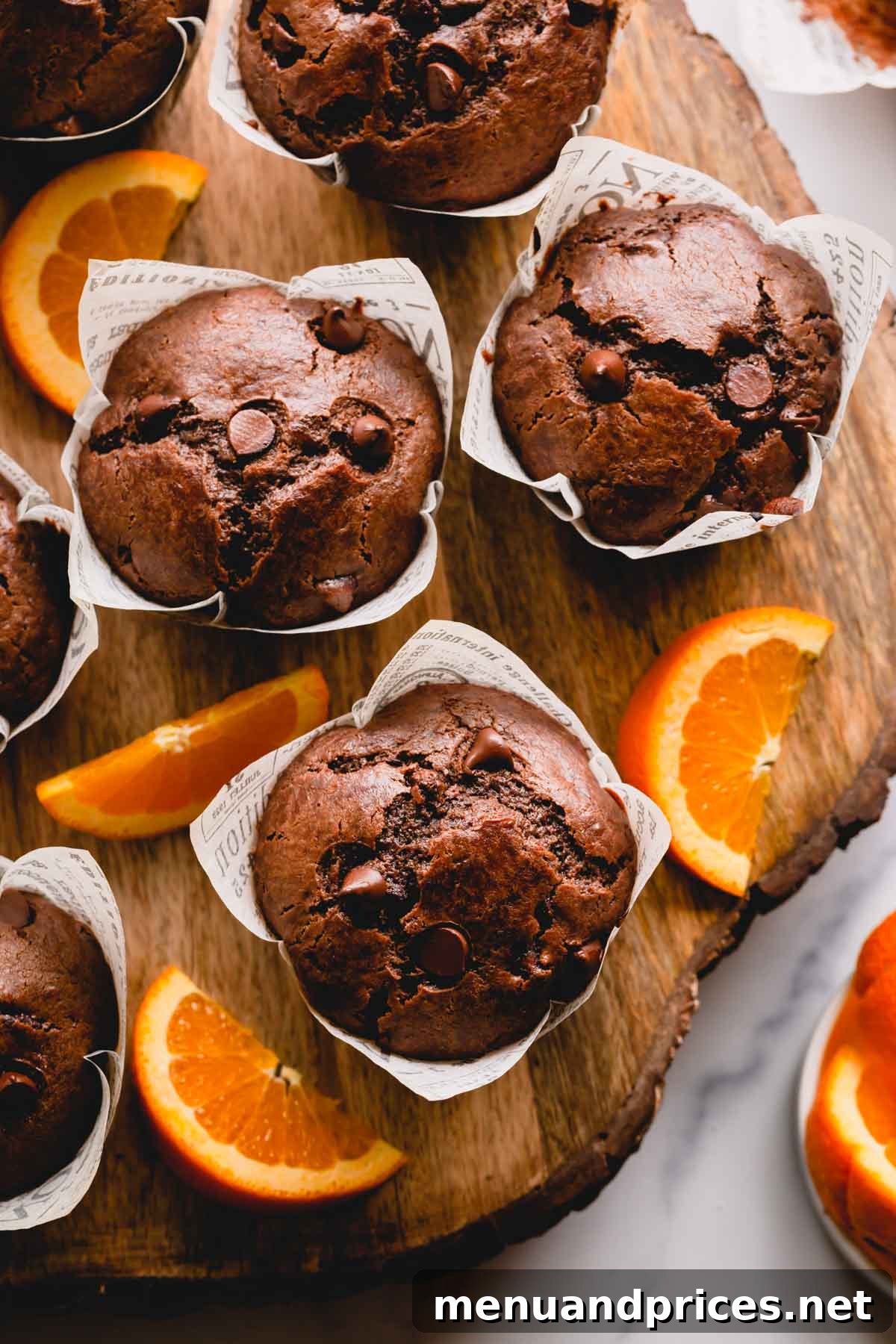 Zesty Orange Chocolate Delights 3 A close-up of baked chocolate muffins adorned with fresh orange slices, highlighting their rich color and inviting texture.