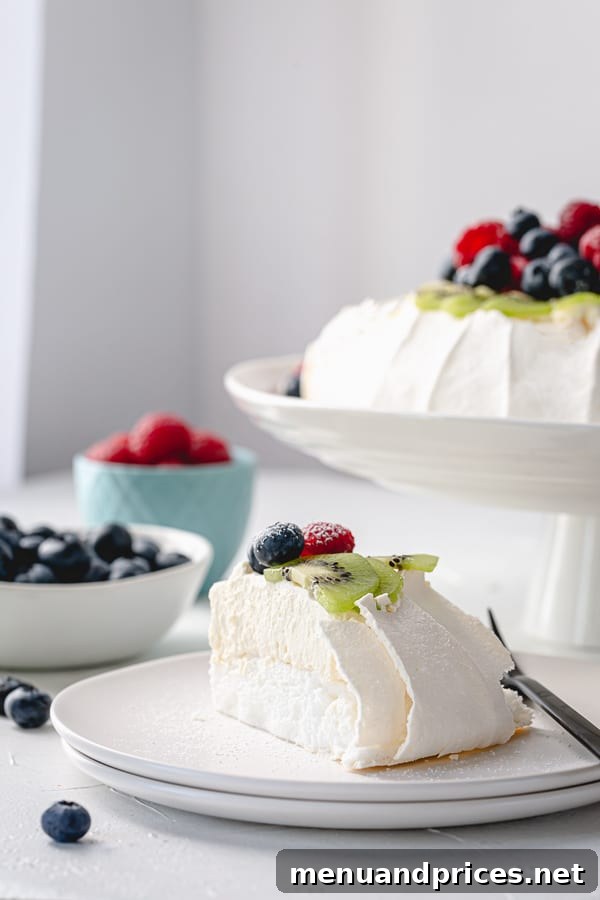 Effortless Pavlova Perfection 9 A stunning close-up of a finished Pavlova with a variety of berries and a generous dollop of whipped cream, highlighting its elegant presentation. #pavlovatips