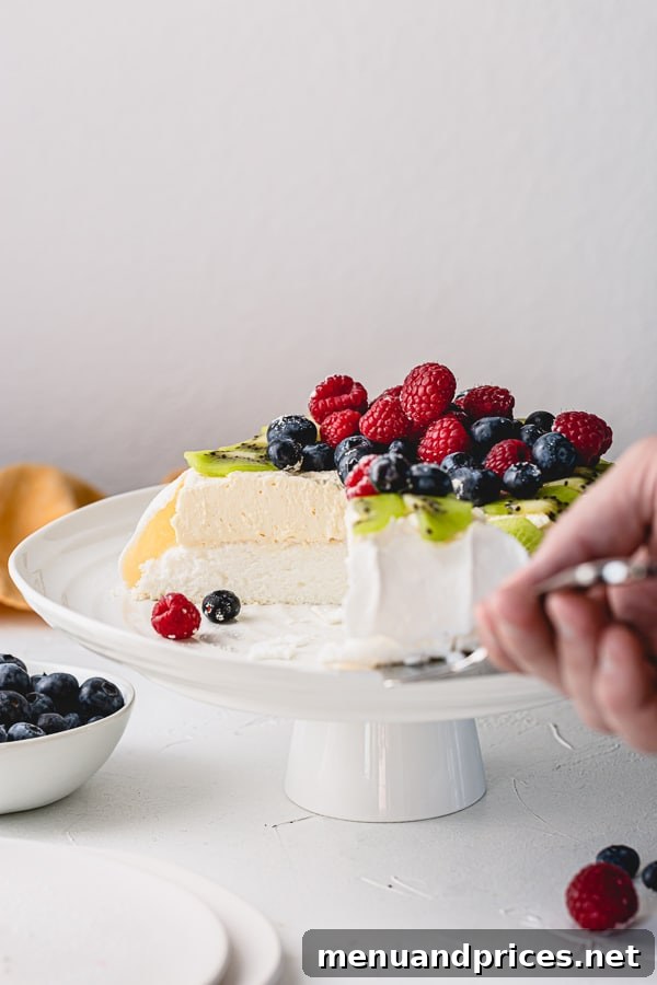 Effortless Pavlova Perfection 10 A vibrant and fresh Pavlova cake, demonstrating its light and delicate nature, with a generous topping of berries and cream. #pavlovadessert