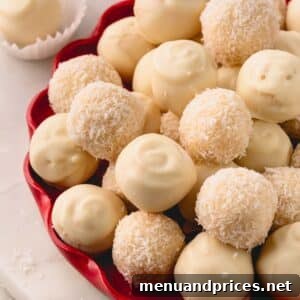 A red platter with white chocolate-coated and desiccated coconut-coated almond coconut balls.
