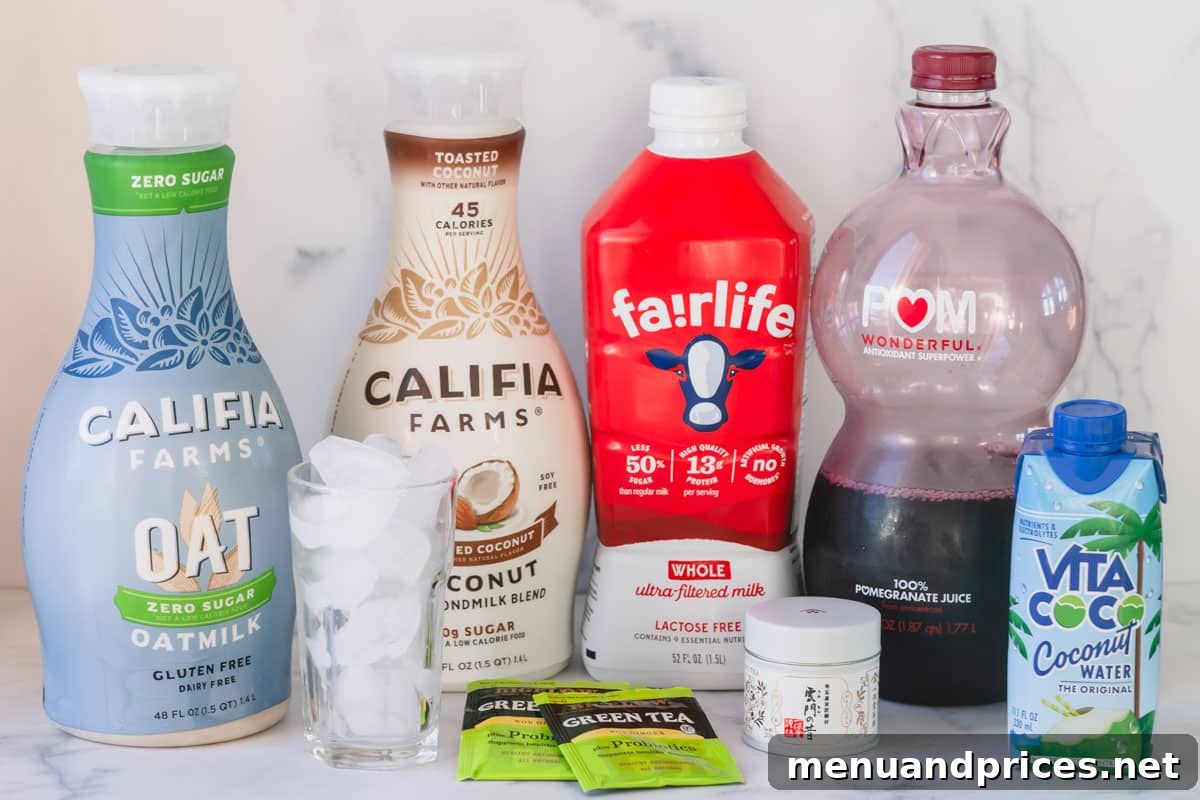 Your Complete Guide to Delicious Smoothies 4 Various liquid bases for smoothies, including oat milk, coconut milk, pomegranate juice, coconut water, dairy milk, and tea bags, displayed on a wooden surface.