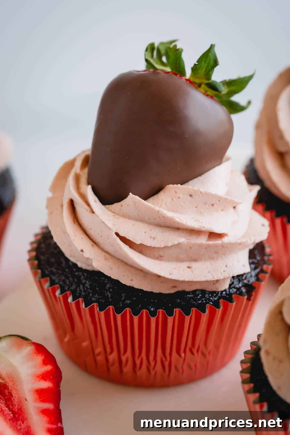 Strawberry Cloud Frosting 8 A chocolate cupcake lavishly topped with strawberry whipped cream frosting and a fresh chocolate-covered strawberry.
