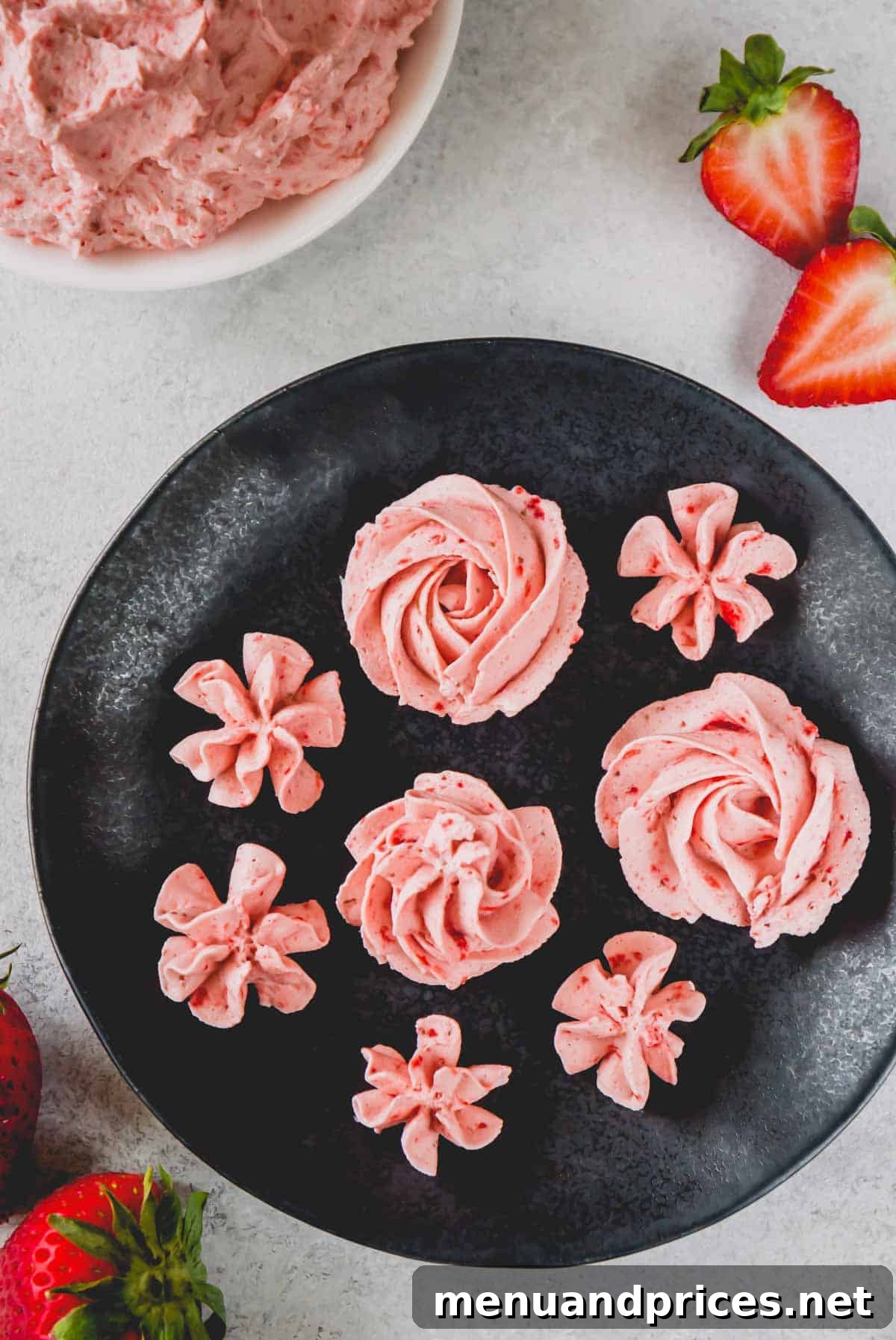 Strawberry Cloud Frosting 9 Overhead image of delicate pink rosettes made of strawberry whipped cream frosting arranged artfully on a white plate.