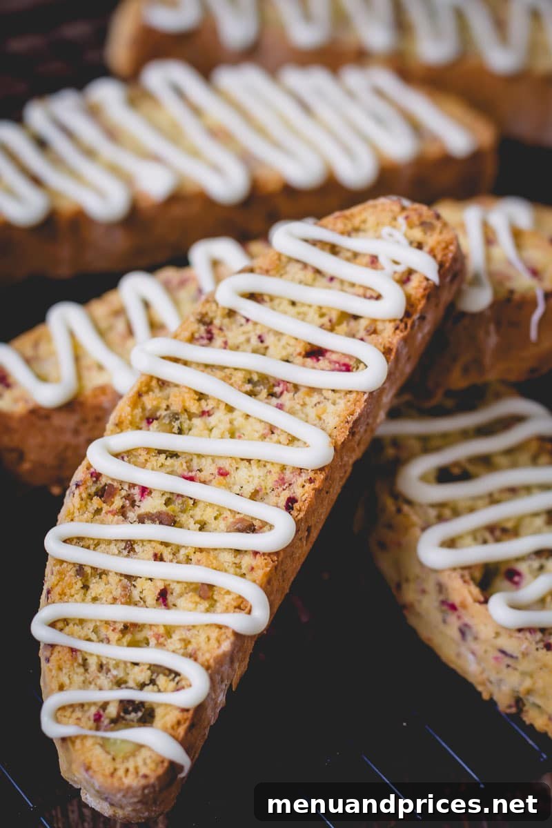 Crisp Cranberry Pistachio Biscotti 4 Cranberry pistachio biscotti topped with a delicate white chocolate drizzle, ready to serve.