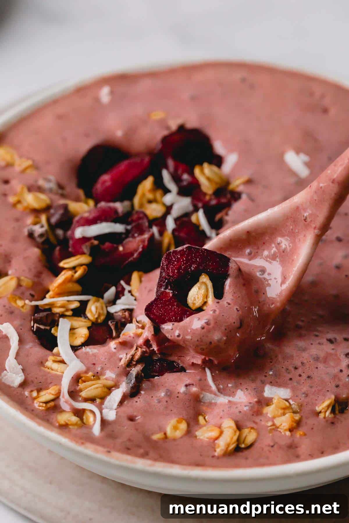 Black Forest Bliss Bowl 2 A spoonful of rich chocolate cherry smoothie with fresh cherries garnishing the side, showcasing its thick, creamy texture.