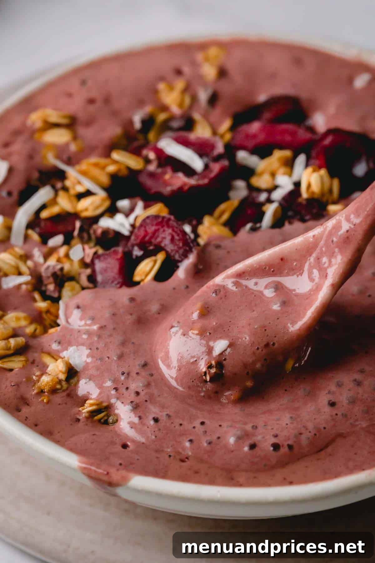 Black Forest Bliss Bowl 7 A close-up shot of a spoonful of chocolate cherry smoothie bowl, highlighting its thick, luxurious texture and vibrant color.
