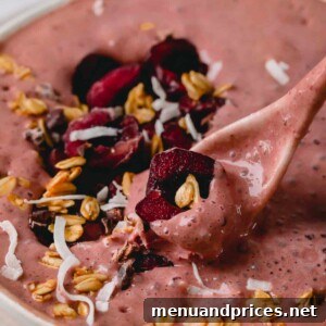 A spoonful of chocolate cherry smoothie with fresh cherries.
