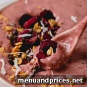A spoonful of chocolate cherry smoothie with fresh cherries.