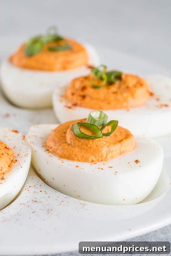 Roasted red pepper deviled eggs with ultra-smooth, creamy filling. The classic deviled egg recipe with big bold flavors and a spicy kick! #roastedredpepper #deviledeggs #easyappetizer