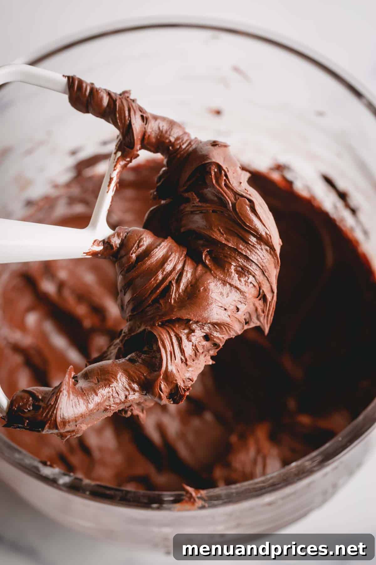 Decadent Chocolate Cream Cheese Frosting 6 A paddle attachment from a mixer, coated in thick, smooth chocolate cream cheese frosting.