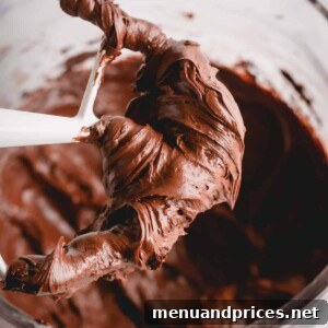 Paddle attachment with chocolate frosting on it, highlighting the rich, smooth texture of the chocolate cream cheese frosting.