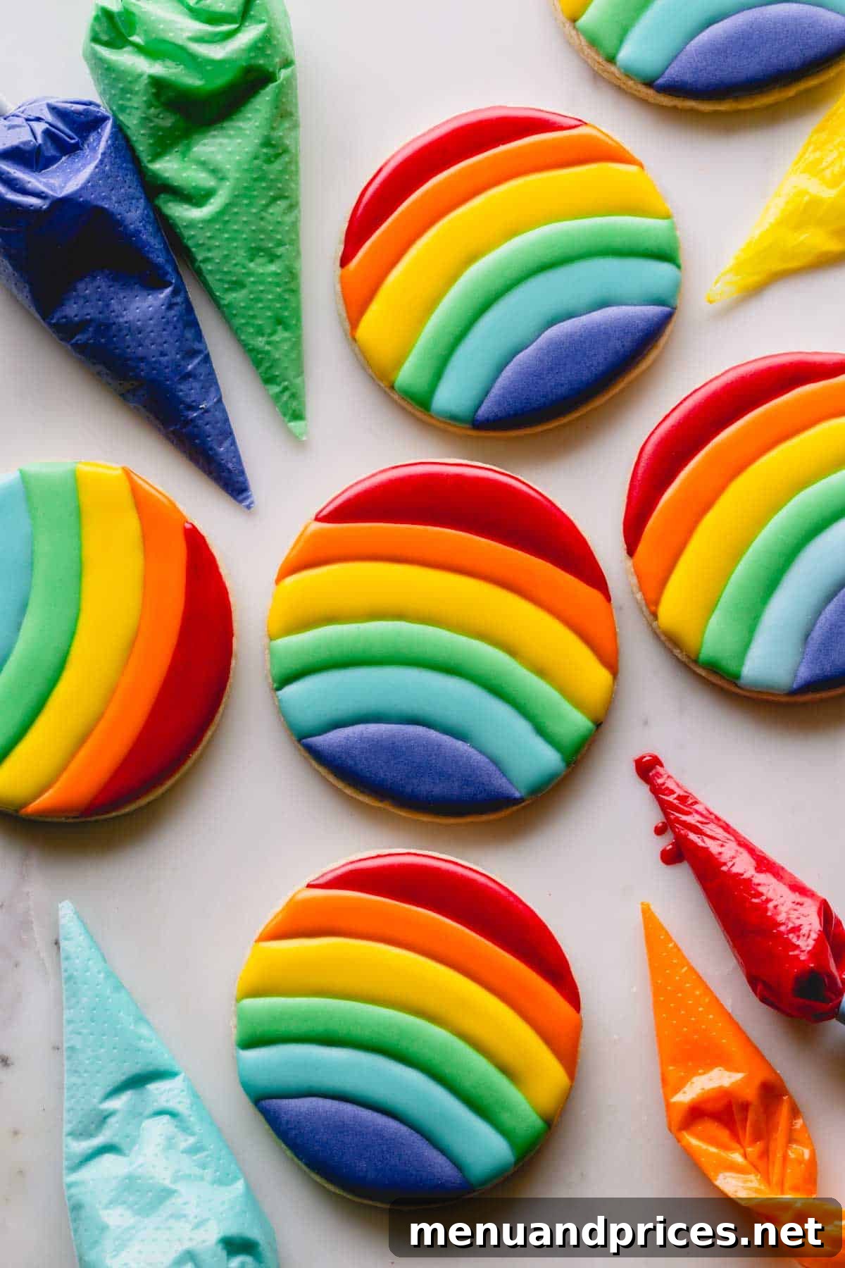 Mastering Royal Icing 2 Round sugar cookies decorated with strips of rainbow royal icing, showcasing vibrant colors and a smooth finish.