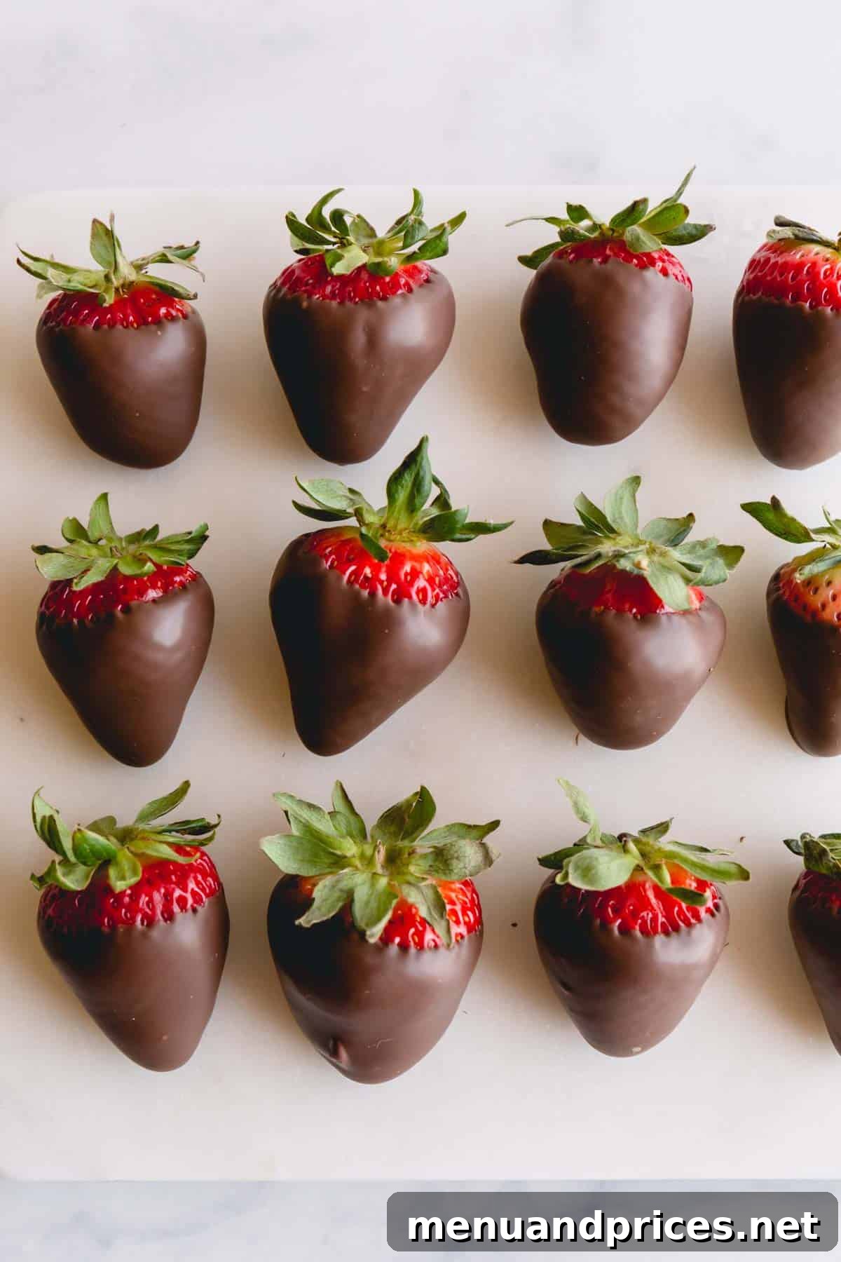 Gourmet Chocolate Strawberries 10 Three rows of chocolate covered strawberries on parchment paper.