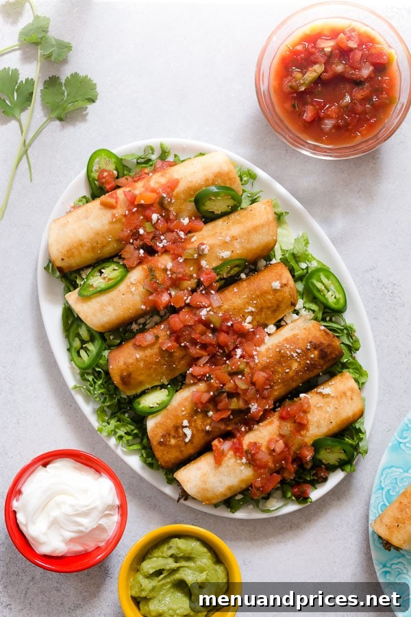 A platter of golden-brown leftover pulled pork flautas, generously topped with vibrant pico de gallo and slices of fresh jalapeño, ready to be served.