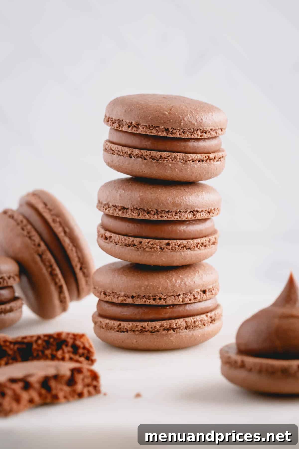 Heavenly Chocolate Macarons 2 Three perfectly piped and filled chocolate macarons stacked on top of each other, surrounded by an array of other delicious chocolate macarons.
