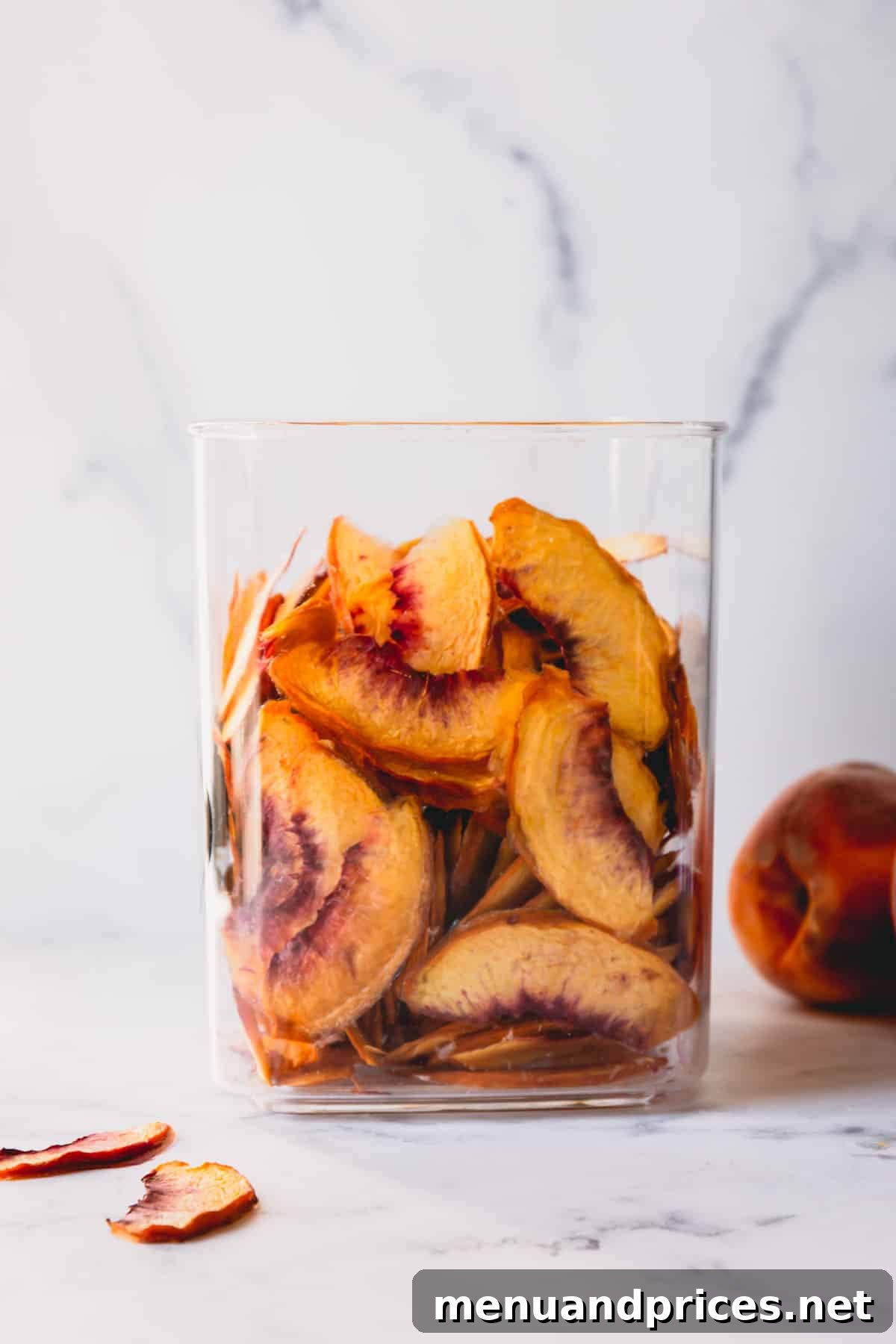 A beautiful glass jar filled with perfectly dehydrated peach pieces, ready for storage.