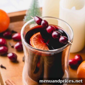 A beautifully presented glass of mulled wine, garnished with fresh cranberries and an orange slice, featured in the recipe card.