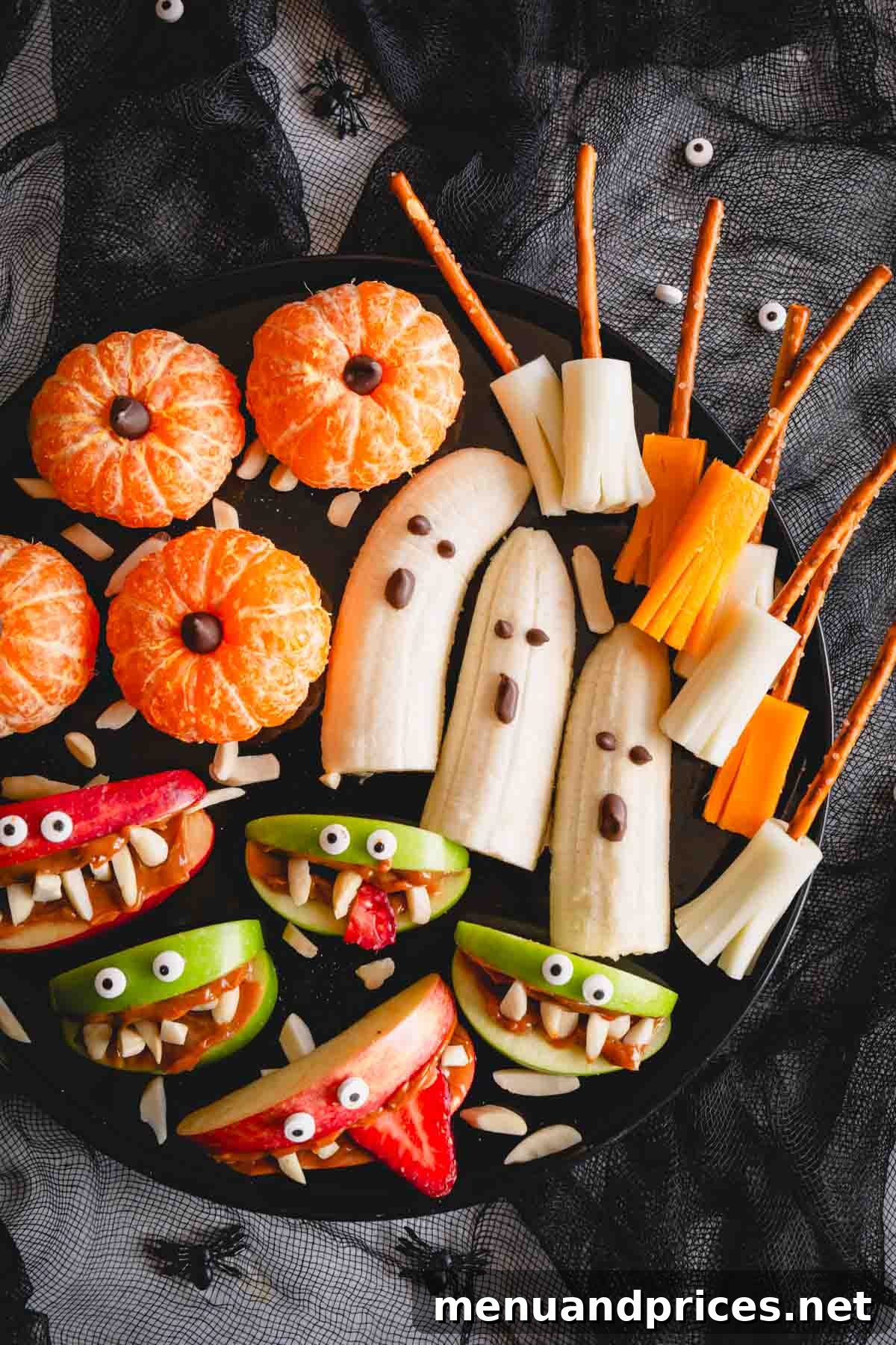 An overhead view of a healthy Halloween snack board, showcasing a variety of colorful and fun treats.