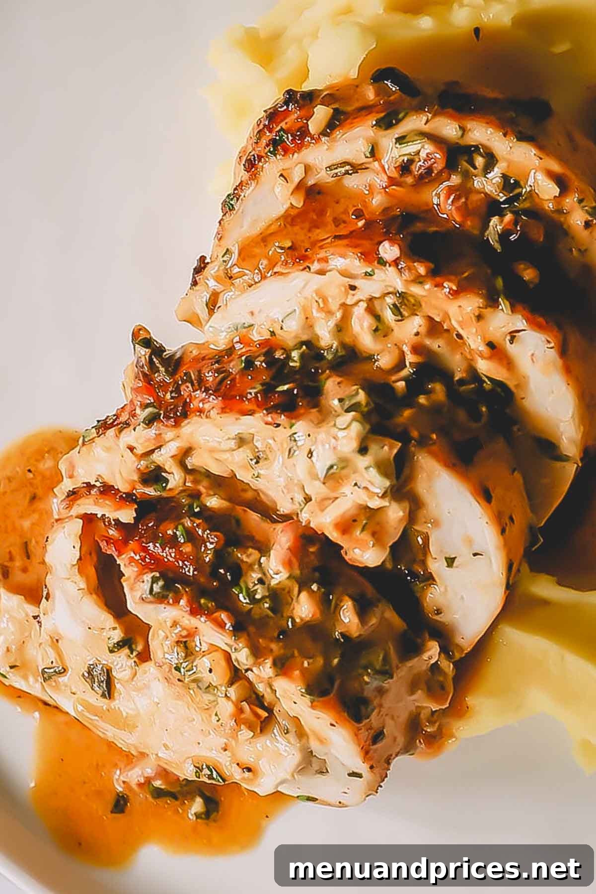 Close up image of perfectly sliced pieces of stuffed turkey breast, showing the creamy filling.